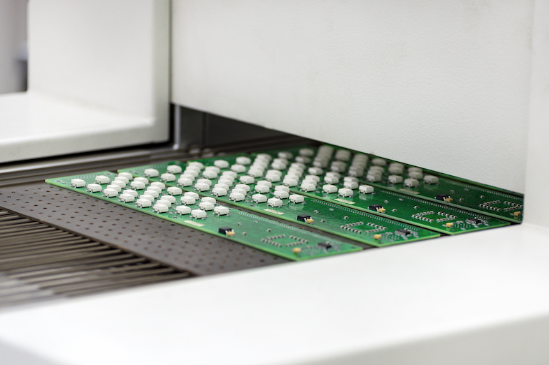 Assembled PCBs Exiting Reflow Oven
